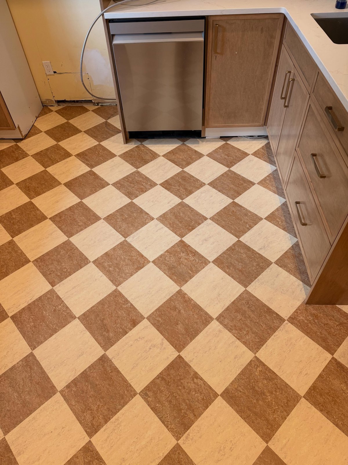 Checkerboard Marmoleum fitted around the kitchen cabinetry.