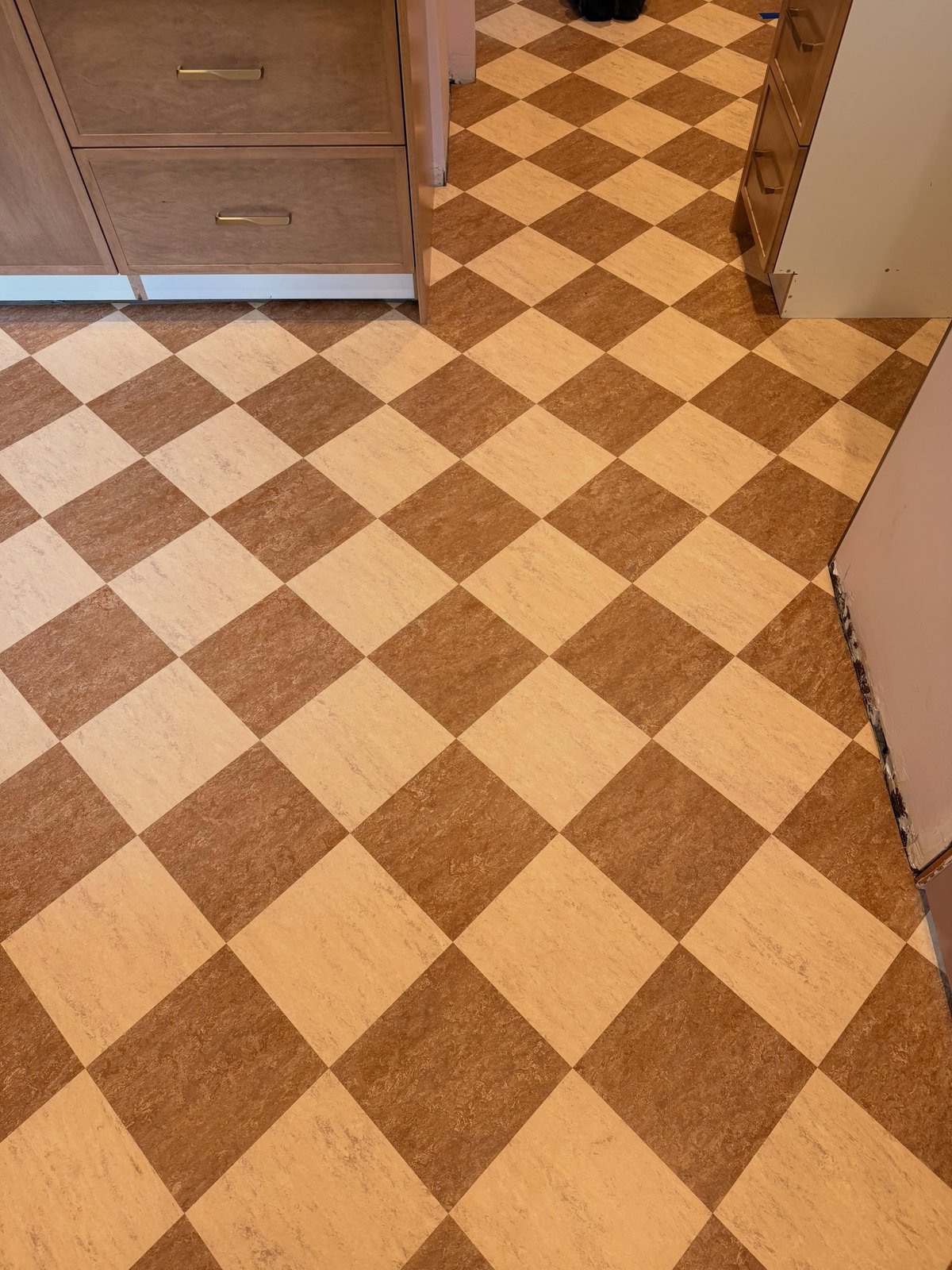 Checkerboard Marmoleum continuing through the kitchen doorway.