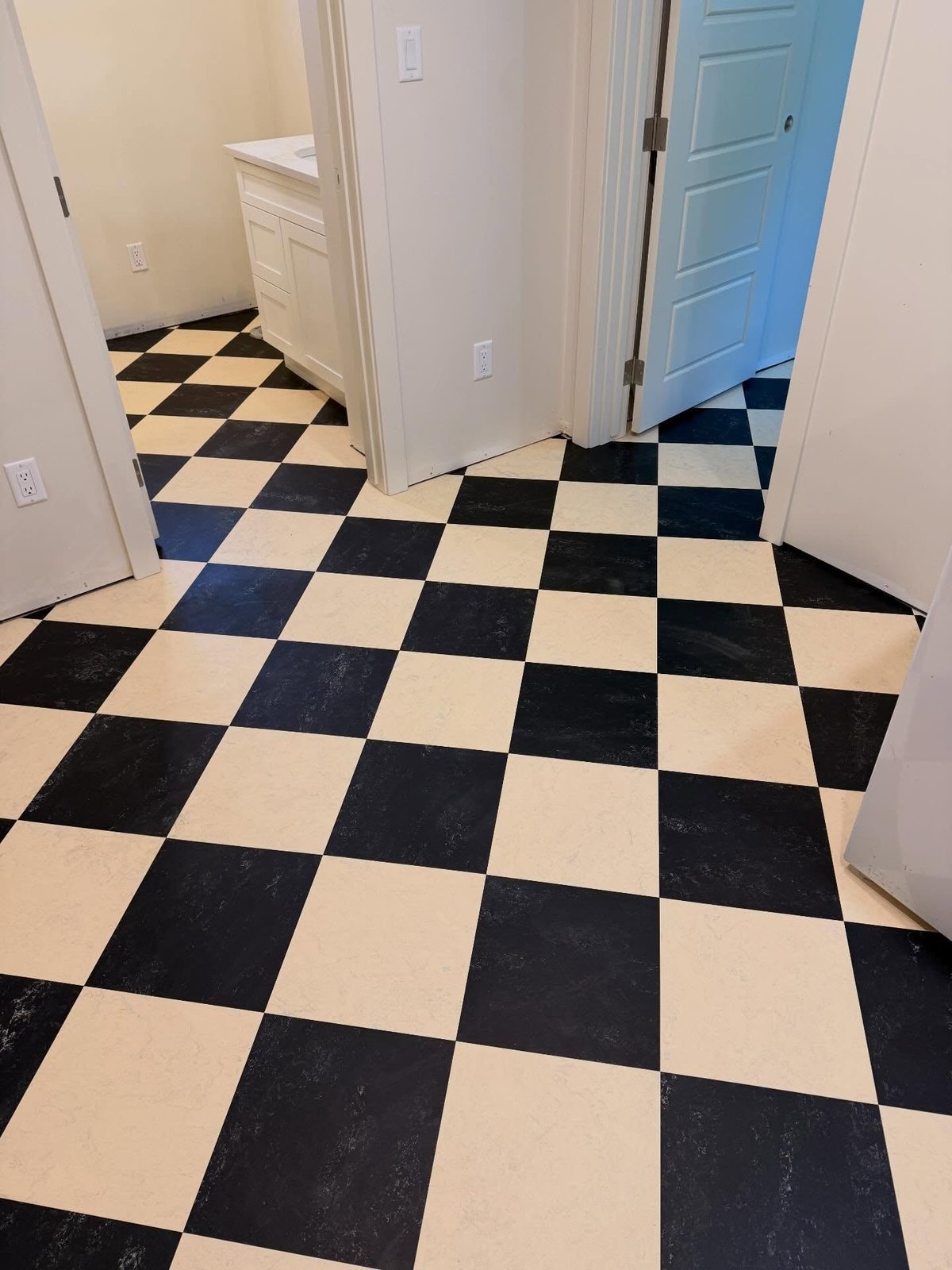 Alternating black and cream squares forming a checkerboard across the floor and adjoining doorways.