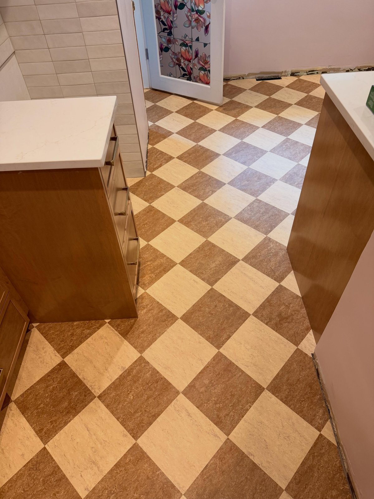 Cream and brown Marmoleum tiles laid diagonally in a diamond checkerboard through the kitchen.