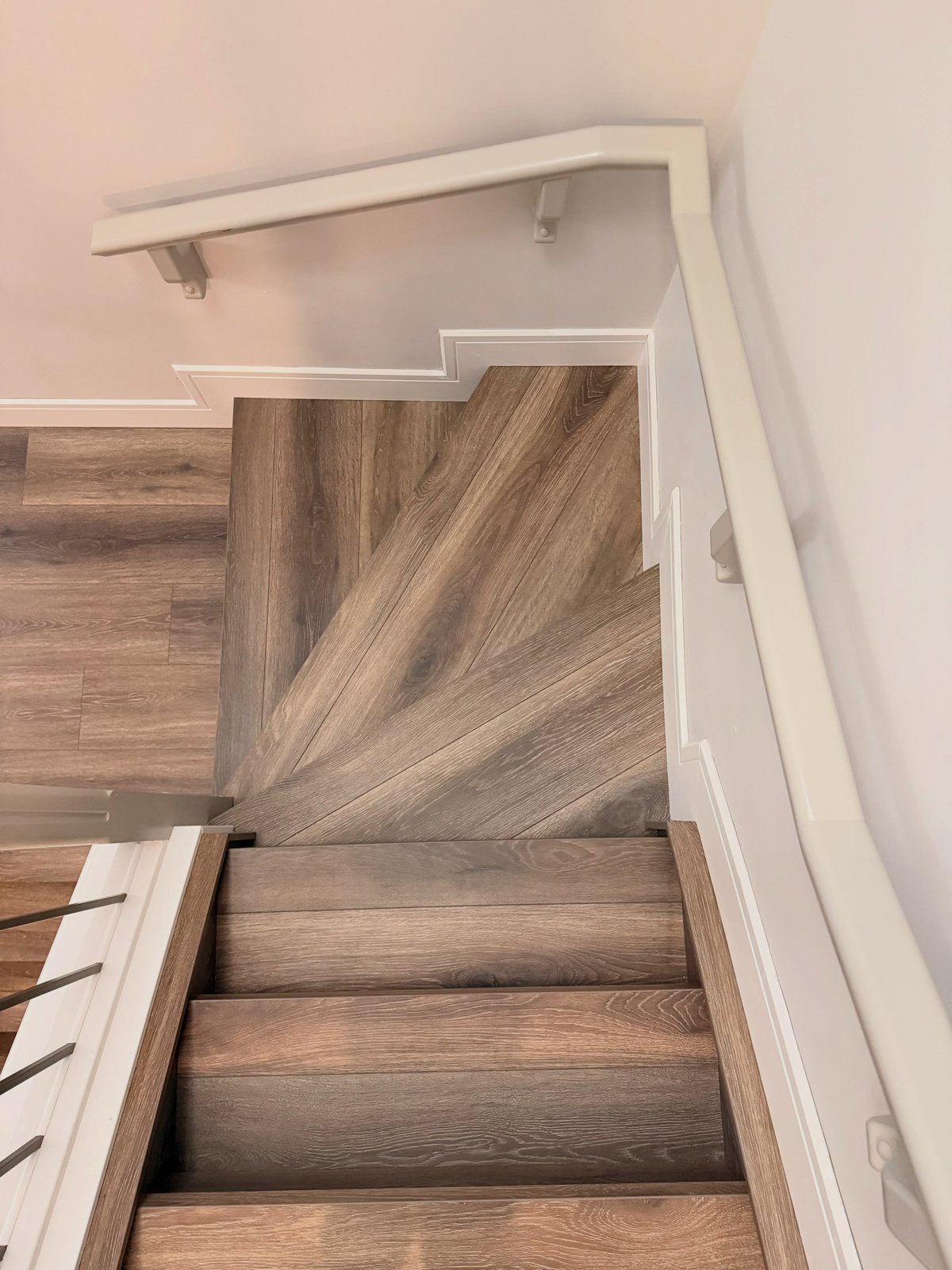 Grey-brown laminate stair treads and a fan-shaped turning section, viewed from above.