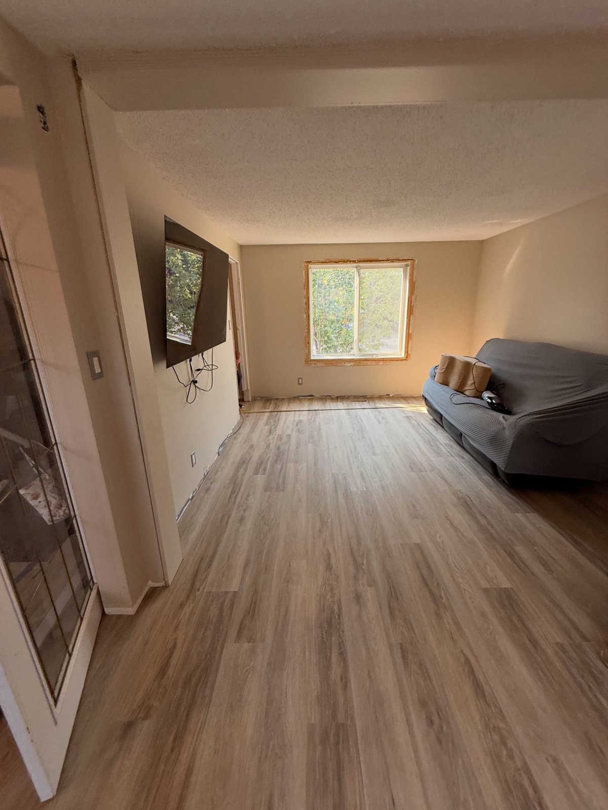 Grey-brown wood-look planks laid lengthwise across the living area.